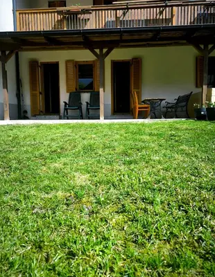 a house with a large yard of green grass at Garden Apartment Pejić - near Bovec, Soča Valley in Bovec