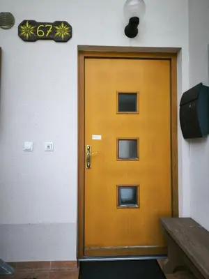 a yellow door in a room with a bench at Garden Apartment Pejić - near Bovec, Soča Valley in Bovec