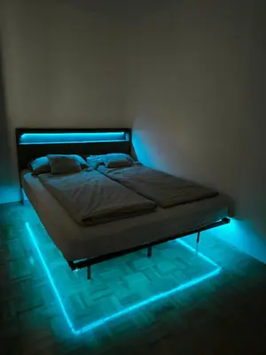 a bedroom with a bed with blue lights on it at Garden Apartment Pejić - near Bovec, Soča Valley in Bovec