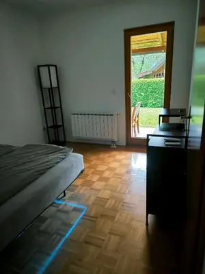 a bedroom with a bed and a wooden floor at Garden Apartment Pejić - near Bovec, Soča Valley in Bovec