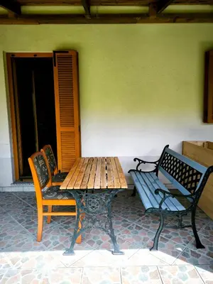 a table and two chairs and a wooden table and bench at Garden Apartment Pejić - near Bovec, Soča Valley in Bovec