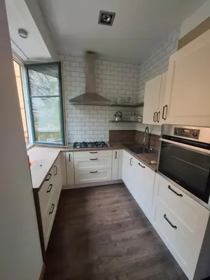 a kitchen with white cabinets and a stove top oven at Feel good Stay at Dragon bridge Apartment in Ljubljana