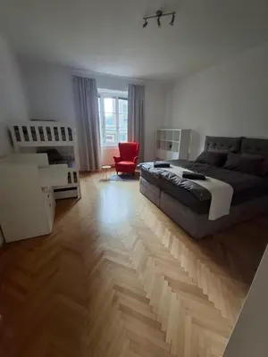 a bedroom with a bed and a red chair at Feel good Stay at Dragon bridge Apartment in Ljubljana