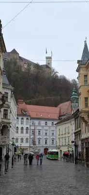 a group of people walking down a street with umbrellas at Feel good Stay at Dragon bridge Apartment in Ljubljana