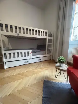a bedroom with two bunk beds and a red couch at Feel good Stay at Dragon bridge Apartment in Ljubljana