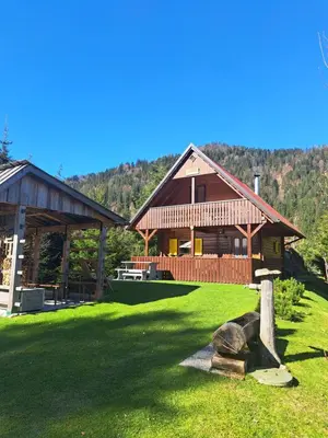 a large wooden house in a grassy field at Na Rebri in Luče