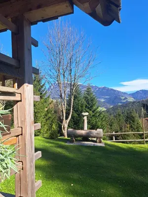 a wooden fence in a yard with mountains in the background at Na Rebri in Luče