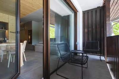 a room with two chairs and a table and a kitchen at Alpine Nest Bovec in Bovec