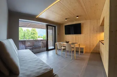 a room with a bed and a table and a television at Alpine Nest Bovec in Bovec