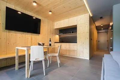 a dining room with a table and a tv on a wall at Alpine Nest Bovec in Bovec