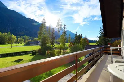 a balcony with a view of a field and mountains at Chalet Gorske Sanje - Kranjska Gora in Gozd Martuljek