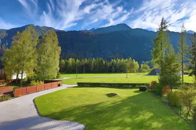 a large grassy field with mountains in the background at Chalet Gorske Sanje - Kranjska Gora in Gozd Martuljek