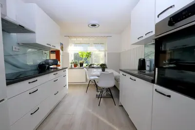 a kitchen with white cabinets and a dining table at Chalet Gorske Sanje - Kranjska Gora in Gozd Martuljek