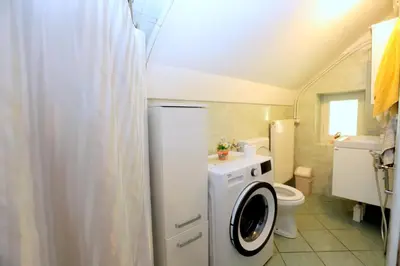 a bathroom with a washing machine and a toilet at Chalet Gorske Sanje - Kranjska Gora in Gozd Martuljek