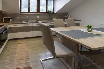 a kitchen with a large wooden table and chairs at Lili Rooms in Stahovica