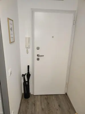 a white door in a room with a wooden floor at MCS Metro Residence in Ljubljana