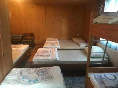 a room with four bunk beds in a cabin at Planinski dom - Mihov dom na Vršiču in Kranjska Gora