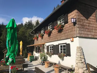 a building with a green umbrella in front of it at Planinski dom - Mihov dom na Vršiču in Kranjska Gora
