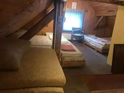 a attic bedroom with two beds and a window at Planinski dom - Mihov dom na Vršiču in Kranjska Gora