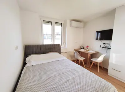 a bedroom with a bed and a table and chairs at Apartment Twin 2 in Ljubljana