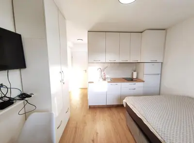 a bedroom with white cabinets and a bed and a sink at Apartment Twin 2 in Ljubljana