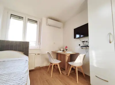 a bedroom with a bed and a table and chairs at Apartment Twin 2 in Ljubljana