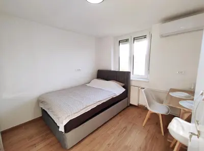 a bedroom with a bed and a table and a chair at Apartment Twin 2 in Ljubljana