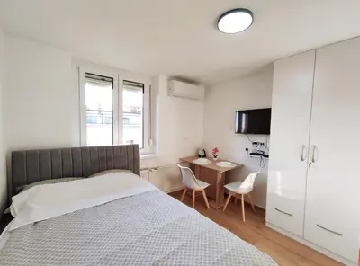 a bedroom with a bed and a table with chairs at Apartment Twin 2 in Ljubljana