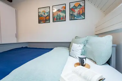 a bedroom with a bed with a blue and white bedspread at Misty May Apartment in Bovec