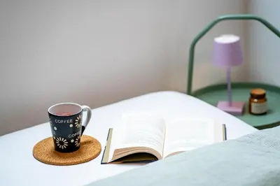 a book and a cup of coffee on a bed at Misty May Apartment in Bovec