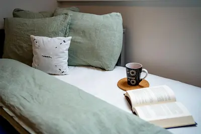 a book and a cup of coffee on a bed at Misty May Apartment in Bovec