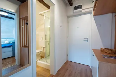a small bathroom with a toilet and a glass door at Misty May Apartment in Bovec