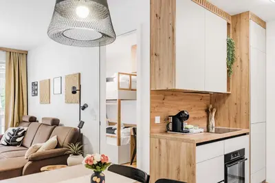 a kitchen and living room with a couch and a table at Mountain Melody Kranjska Gora in Kranjska Gora