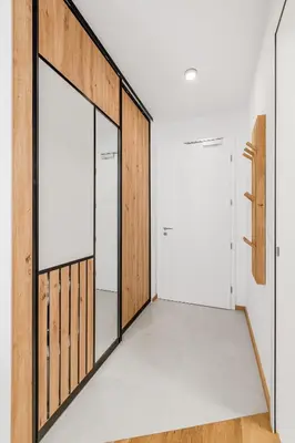 a pivot door in a room with white walls and wood at Mountain Melody Kranjska Gora in Kranjska Gora