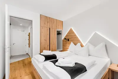 two beds in a bedroom with white walls and wooden floors at Mountain Melody Kranjska Gora in Kranjska Gora