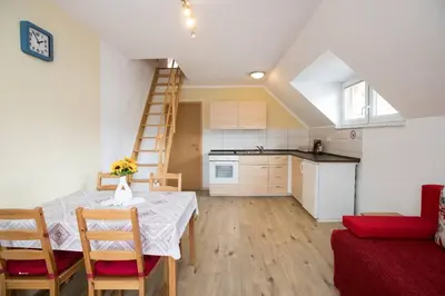 a kitchen and a dining room with a table and chairs at Apartmaji Daša & Anže in Bohinj