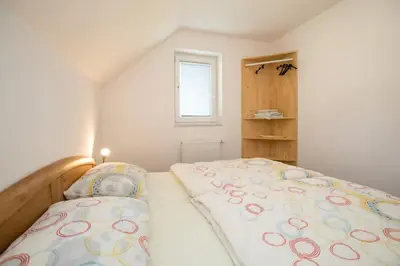 a small bedroom with a bed and a window at Apartmaji Daša & Anže in Bohinj