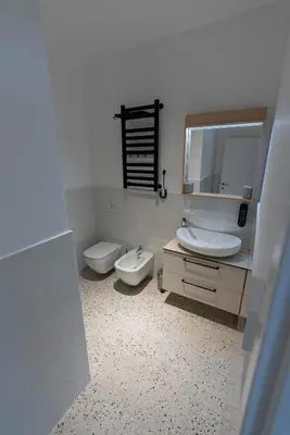 a bathroom with two toilets and a sink and a mirror at ALPEART GOZD MARTULJEK HOLIDAY unit in Kranjska Gora