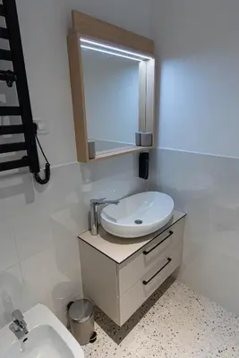 a white bathroom with a sink and a mirror at ALPEART GOZD MARTULJEK HOLIDAY unit in Kranjska Gora