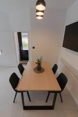 a wooden table with chairs in a room at ALPEART GOZD MARTULJEK HOLIDAY unit in Kranjska Gora