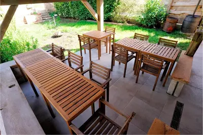 a group of wooden tables and chairs on a patio at Glamping Tlaka in Gornji Grad