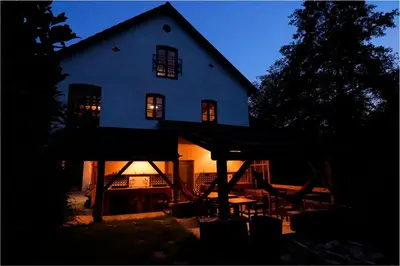 a large white house with lights on in the dark at Glamping Tlaka in Gornji Grad