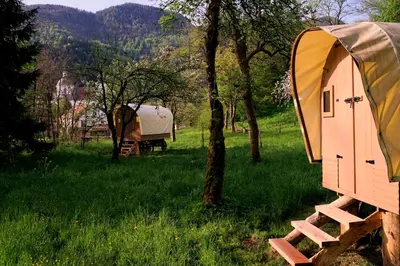 a tent and a trailer in a field at Glamping Tlaka in Gornji Grad