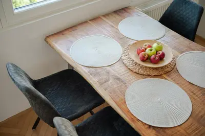 a wooden table with white plates and a bowl of fruit at Peaceful City Stay in Ljubljana