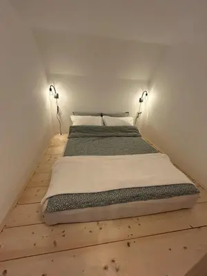 a large bed in a room with two lamps at Apartma Vrbnjak in Bohinj