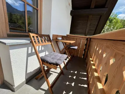a wooden chair sitting on the balcony of a house at Apartma Vrbnjak in Bohinj