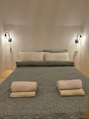 a bedroom with a bed with two towels on it at Apartma Vrbnjak in Bohinj