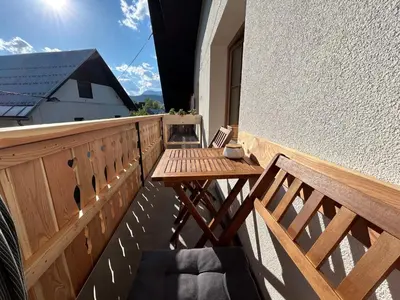a balcony with a wooden table and a bench at Apartma Vrbnjak in Bohinj