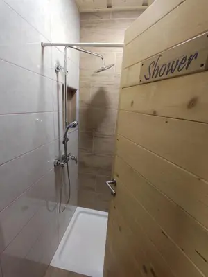 a bathroom with a shower and a shower door at Village Vista in Rob