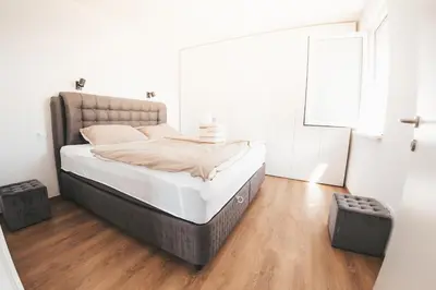 a bedroom with a bed in a white room at Stork's Nest - Moravske Toplice in Moravske Toplice